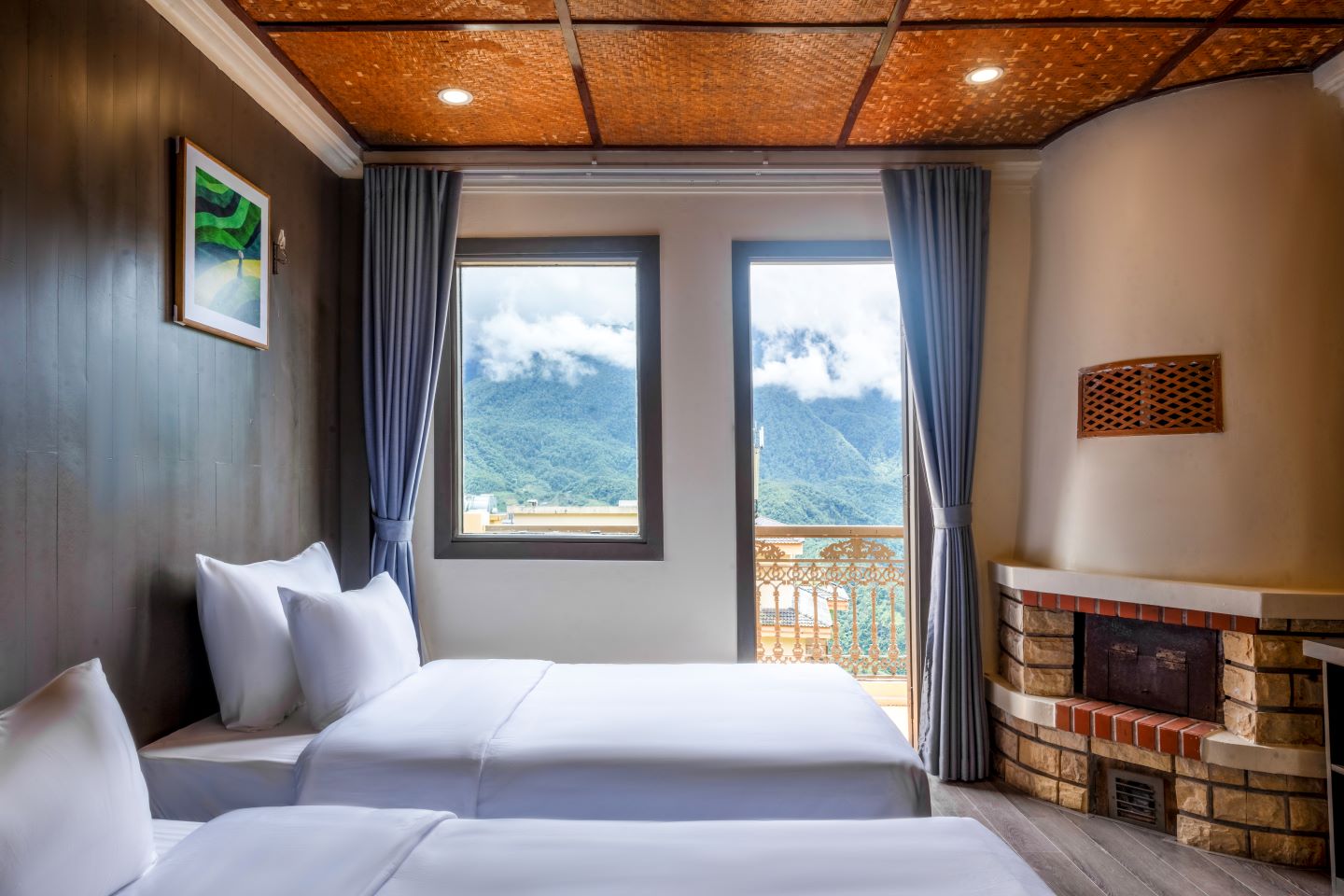 Twin room with corner fireplace and a balcony framing the mountains